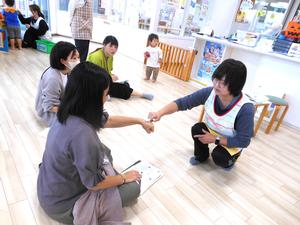 看護師が参加者ママの手の甲にワセリンを塗っている様子