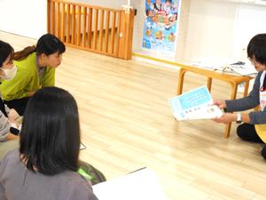 考資料の写真を見せる看護師と食い入るように見ているママ達の様子