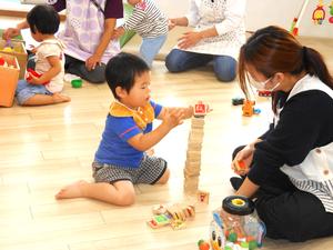 「託児の実践」で子どもと一緒に積み木で遊ぶ参加者の様子