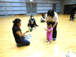 講師の先生が持つタンバリンを叩き手を叩いて自画自賛している女の子の様子