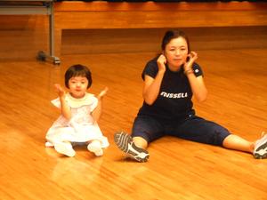 講師の先生と、隣に座って先生の真似をする女の子の様子