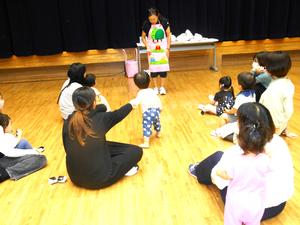 先生によるエプロンシアター「3匹のこぶた」を見ている親子の様子