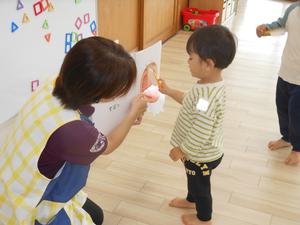 『おやさいどうぞ』の仕掛け絵本におもちゃの包丁を近づける男の子の様子
