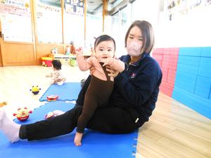 ママに支えられて立っている女の子の様子