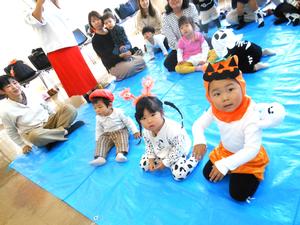 仮装をしている子ども達が、読み聞かせ前に手遊びをしている様子