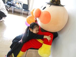 大きなアンパンマンの人形に抱き着いている女の子の写真