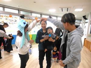 先輩ママと外国語で遊ぼうのコーナーで歌に合わせてトンネルくぐりをしている親子の様子