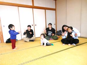 読み聞かせ前の手遊びを楽しむ親子の様子