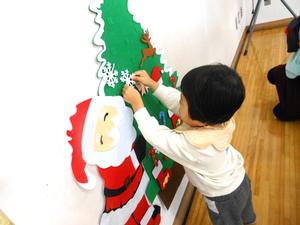 クリスマスツリーに飾り付けをしている女の子の様子