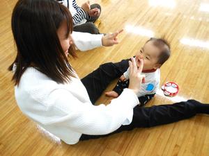 講師の先生の指導の下、手遊びを楽しむ親子の様子