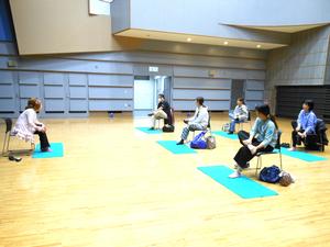 講師の先生の指導の下、足首を回すストレッチをしている様子