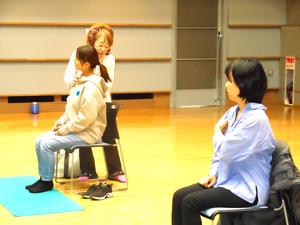 講師の先生に腕のマッサージをしてもらっているママの様子