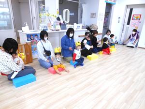 入場した誕生児の親子が並んで座っている様子