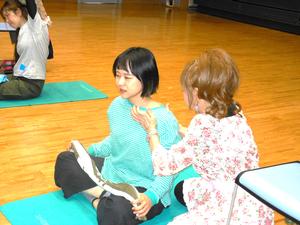 講師の先生に肩のマッサージをしてもらうママの様子