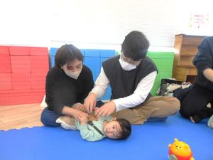 ふれあい遊びで赤ちゃんにコチョコチョしているパパとママの様子