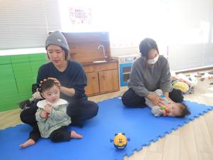 歌に合わせてふれあい遊びを楽しむ2組の親子の様子