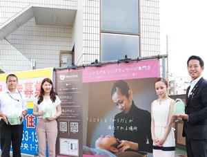 屋外の看板前で記念撮影