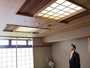 中央公民館の和室の照明カバーを見つめる市長