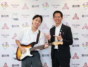 ギターを構えた福田さんと市長との記念撮影