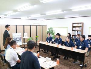 会議室内で説明を受ける市長と市職員