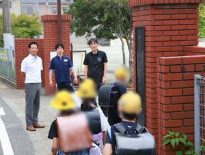 校門で笑顔で登校児童に挨拶をする市長