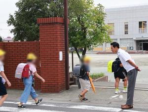 校門で笑顔で登校児童に挨拶をする市長