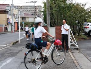 笑顔で登校生徒に手を振って挨拶をする市長