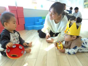 応援隊の赤ちゃんと見つめ合う誕生児の赤ちゃんと笑顔のママの様子