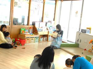 小さい絵本を読む保育士の様子