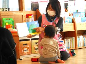 読む聞かせをしている保育士の目の前まで来て見ている男の子の様子