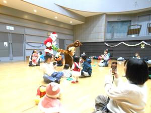 参加者親子の周りを練り歩くサンタクロースとトナカイの様子