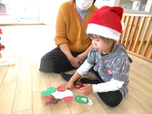 紙皿に画用紙をペタペタ貼る女の子の様子