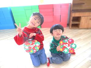 完成したリースを見せてポーズをとる姉弟の写真