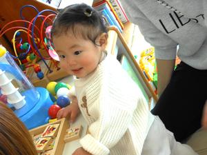 工作に見向きもせず、つかまり立ちで遊ぶ女の子の様子