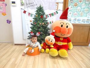 クリスマスフォトスポットで、頭にサンタの飾りをつけて写真を撮る赤ちゃんの様子