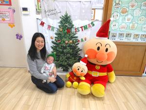 クリスマスフォト写真を撮る、赤ちゃんを抱いたママの様子