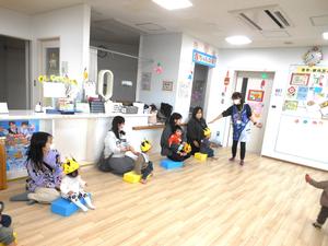 誕生児の子がカラー積み木に座っている様子