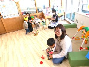 おもちゃで遊びながら誕生児お祝いをする、応援隊の様子