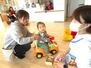 アンパンマンの車に乗っている赤ちゃんと後ろを押すママの様子