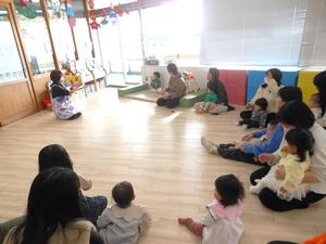 保育士が読む絵本を見ている親子の様子