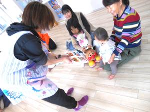 お弁当の絵本を子ども達に近づける保育士の様子