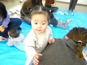 ママの背中でつかまり立ちしている赤ちゃんの様子