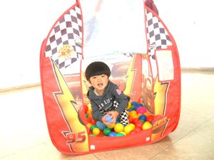 ボールハウスに入ってボールを投げようとしている男の子の様子