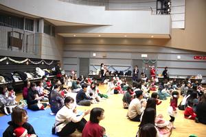 お姉さん達の歌や体操を見ているたくさんの親子の様子