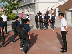 校門で登校生徒に笑顔で挨拶をする市長