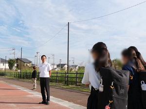 校門で登校生徒に笑顔で挨拶をする市長