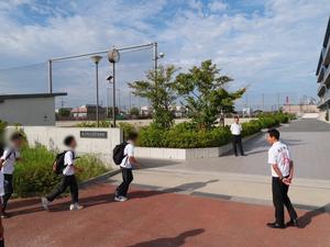 校門で登校生徒に笑顔で挨拶をする市長