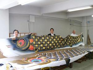 佐藤社長と市長と土屋参与で鯉のぼりを持って記念撮影