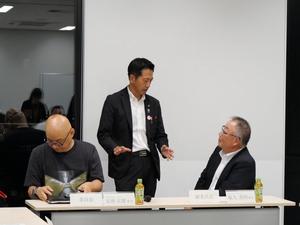 閉会後に委員と話をする市長