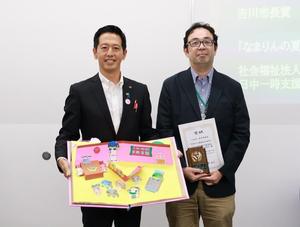 受賞作品を手に市長と受賞者の記念撮影